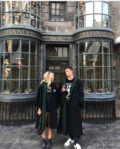 a man and woman standing in front of a harry potter's house with their arms around each other