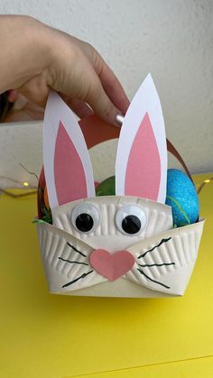 someone is decorating an easter basket with bunny ears