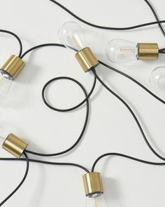 three light bulbs connected to wires on a white surface