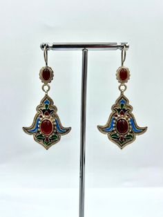 Statement silver dangle turkmen earring. Red carnelian stone, a precious stone, was used in bohemian earrings. Cloisonne earring decorated with colorful and high quality cloisonne. Tribal earrings made very clean and precise by masters. Turkmen coupes with this unique design are completely handmade. Total weight of ethnic earrings is 7.9 grams PRODUCT İNFORMATİON : Material : SİLVER Weight   : 7.90 GR Length   : 5.5 CM Width     : 2.8CM DELİVERY TİME : AMERİCA                  : 3-7 DAYS EU COUN Vintage Multicolor Brass Earrings, Ornate Red Teardrop Jewelry, Ornate Red Drop Earrings, Multicolor Brass Drop Earrings, Ornate Red Dangle Earrings, Vintage Red Brass Earrings, Ornate Pendant Earrings For Festive Occasions, Vintage Earrings With Latkans For Gift, Vintage Handmade Pendant Earrings