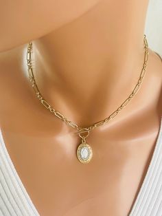 "This is a stunning 14k gold-filled choker chain necklace with a unique two-tone miraculous medal that hangs from toggle clasp in front.  This gorgeous pendant measures 24x15mm, is 925 Sterling silver with gold plating to give it a two-tone look. Made here is the USA by skilled silversmiths this pendant is absolutely incredible. This lovey paper clip chain is made of 14 karat gold filled or can be ordered and 925  sterling silver.  Links measure 8x4mm and 4mm, 3-1 pattern.  Model is wearing a 15\" choker length.  Please measure around your neck to where you want the toggle to land. Comes in a gift box, ready to present! Necklace maybe ordered with a 925 sterling silver chain. Not shown." Elegant Miraculous Medal Necklace, Dainty Necklace With Miraculous Medal, Gold Miraculous Medal Jewelry, Choker Chain, Necklaces Gold, Gold Charm Necklace, Charm Necklaces, Miraculous Medal, Chain Choker Necklace