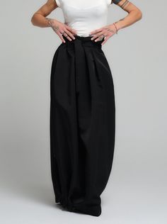 Make a bold statement with our high-waist skirt, the epitome of tailored elegance. This skirt is fashioned from premium polyester, delivering a smooth finish with a substantial feel that gracefully flows with every step. The design is accentuated by a tasteful belt that cinches the waist, while the elasticated back ensures a snug and comfortable fit. Its voluminous silhouette and sleek lines make it a versatile piece for both office wear and evening affairs. FEATURES:Includes a chic belt, elasticated back for comfort, and a high-waist cut 100% Handmade. SIZE & FIT: Fit: A relaxed fit with room to moveModel is wearing size Small or S/M View our SIZE CHART before ordering MATERIALS & CARE: Content: Polyester Care: Dry cleaning only SHIPPING: Made to order, processing time is 15 working days Elegant Wide Leg Bottoms For Semi-formal Occasions, Chic Black Semi-formal Pants, Chic Party Maxi Skirt With Elastic Waistband, Chic Denim Skirt With Belt Loops, Elegant Black Semi-formal Wide Leg Pants, Elegant Fitted Skirt With Elastic Waistband, Chic Pleated Skirt For Formal Occasions, Elegant Flowy Skirt With Elastic Waistband, Elegant Fitted Maxi Skirt With Elastic Waistband