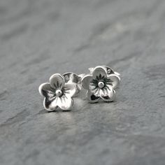 Cherry Blossom Sterling Silver Stud Earrings Modern botanical design portrays the natural beauty of the sakura flower. 6.5mm across.  Sterling silver posts and sterling silver ear backs. You may also like: STACKING RINGS: https://www.etsy.com/shop/KiraFerrer?ref=hdr_shop_menu§ion_id=39230144&page=2#items STATEMENT RINGS: https://www.etsy.com/shop/KiraFerrer?ref=hdr_shop_menu§ion_id=5254786 EARRINGS: https://www.etsy.com/shop/KiraFerrer?ref=hdr_shop_menu§ion_id=7937255 HOOPS: https://www.etsy.com Delicate Flower Charm Earrings, Nickel Free Nature-inspired Flower Earrings, Sterling Silver Birth Flower Earrings, Adjustable 3d Flower Earrings, Blossom Flower Earrings For Pierced Ears, Blossom Color Flower Earrings For Pierced Ears, Dainty Adjustable Flower Earrings, Blossom Color Flower Earrings, Nature-inspired Adjustable Flower Earrings