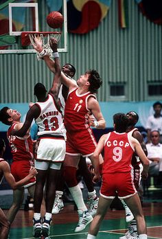 the basketball players are trying to block the ball from going into the basket during a game