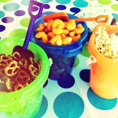 three buckets filled with food sitting on top of a polka dot tablecloth covered table