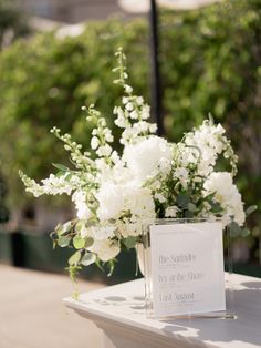 a vase with white flowers sitting on top of a table