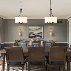 a dinning room table and chairs in front of a painting