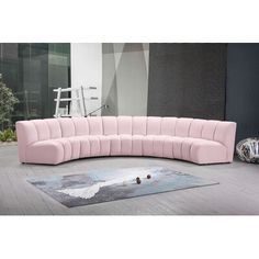 a pink sectional sofa sitting on top of a rug