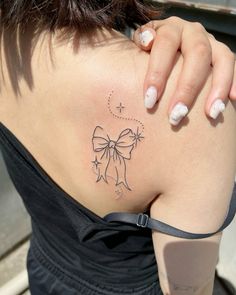 a woman with a bow tattoo on her back shoulder and right side ribcage