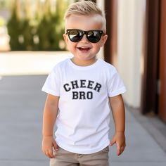 This is a perfect shirt for any Cheer Brother.  It would also make a perfect gift for a cheer Brother.   Uplift any child's wardrobe with a custom kid's t-shirt. The Bella Canvas short sleeve tee for toddlers is a 100% Airlume combed and ring-spun cotton jersey with a tear-away label for extra comfort. Choose your favorite color out of a big variety, and make unique staples that toddlers will happily wear every day.  .: 100% airlume combed and ring-spun cotton (fiber content varies for different colors) .: Extra light fabric (3.9 oz/yd² (132 g/m .: Tear-away label Funny Cheer Brother Shirts, Graphic Tee T-shirt For Cheerleading, White Fan Apparel Tops For Cheerleading, White Team Spirit T-shirt For School, Cotton T-shirt For Cheerleading In Fan Apparel Style, White Cheerleading Fan Apparel T-shirt, White Team Spirit School T-shirt, Cotton T-shirt For Cheerleading Fan Apparel, White Sports Fan Top For Cheerleading