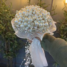 someone is holding a bouquet with pearls on it