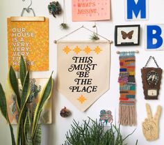 there are many different items hanging on the wall next to each other, including plants and magnets