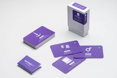 four purple business cards sitting on top of each other next to a box with the letter q in it