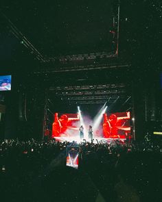 the stage is lit up with bright lights and people are standing in front of it