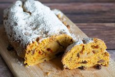 there is a cake that has been cut in half on a cutting board with powdered sugar