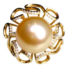 It is a flower motif Pearl ring with ribbon-like petals surrounding the Golden South Sea Pearl. At the edge of the petals there are several round diamonds adding sparkle to the ring. The Golden South Sea Pearl is measuring 13mm-14mm The pearl is of Excellent Lustre and very minor Surface Blemish The Pearl is in Rich Golden Colour with Pink Overtone Total Natural Diamond weight is 0.131 ct US Ring Size is 7 1/2 , The Inner Diameter of the Ring is 17.73 mm Diamond Bracelet Design, Golden Colour, Golden South Sea Pearls, Pearl And Diamond Ring, Sea Pearl, Flower Motif, South Sea Pearls, Sea Pearls, Women Diamond