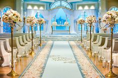 the aisle is decorated with white flowers and gold candelabras for an elegant wedding