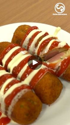 a white plate topped with meat covered in ketchup and mayonnaise strips