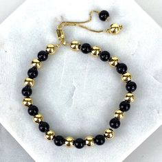 "18k Gold Filled 1mm Box Chain Bracelet Featuring Simulated Onyx Black Bead Ball, Gold Beads, Adjustable Bracelet - Bracelet Size: Thickness: 0.9 mm | Beads Width: 5.8 mm | Length: 9 Inches 💎 With new products daily, quality and competitive prices, in DiJu Jewelry you find the most unique styles of modern designs, always looking for elegance and market trends. *Helping your Jewelry Businesses Grow *Starting your Own Business *Making your Own Collection: DiJu Jewelry ever brings Better Moments f Luxury Classic Black Gold Bracelet, Elegant Black Beaded Bracelet With Adjustable Chain, Elegant Gold Beads With Black Details, Elegant Black Beads With Gold Details, Adjustable Gold Beaded Bracelets With Gemstone, Adjustable Gold Onyx Bracelets, Adjustable Gold Onyx Bracelet, Adjustable Black Bracelets With Gold Beads, Gold Jewelry With Round Black Beads