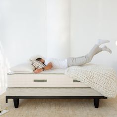 a man laying on top of a mattress in a room