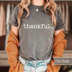 Searching for a minimalist, original, and comfy shirt that will express your overwhelming excitement for Thanksgiving season? Look no further than our "thankful. Comfort Colors Shirt"! This comfortable and stylish shirt is perfect for outdoor activities or relaxing at home. This shirt is sure to keep you cool and comfortable all season long with it's double-needle stitching throughout which makes it highly durable while the lack of side-seams helps the shirt retain its tubular shape.  This origi Fall Soft-washed Tri-blend T-shirt, Soft-washed Tri-blend Fall T-shirt, Gray Text Print T-shirt For Fall, Fall Everyday T-shirt With Screen Print, Gray Relaxed Fit T-shirt For Fall, Everyday Relaxed Fit Shirt With Letter Print, Relaxed Fit Everyday Shirt With Letter Print, Everyday Comfortable Top With Text Print, Comfortable Everyday Top With Text Print