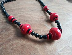 "Chunky vintage necklace, big & bright red beads with smaller black beads and more red disc shaped beads! So totally 80's, (but could be a little older), it measures a total of 24\" plus small clasp. The black beads are a thick plastic/acrylic, but we're not positive on the red beads, they look like thick plastic, but feel like a wood with an acrylic coating? Necklace is in good condition, please see all photos. Offbeat Avenue uses recycled packaging when available." Handmade Retro Red Beaded Necklaces, Handmade Red Retro Beaded Necklaces, Handmade Red Beaded Retro Necklace, Vintage Red Wooden Beads, 80's Fashion, Necklace Big, Red Beads, Chunky Beads, Beaded Statement Necklace