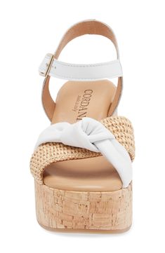 A cork-textured platform enhances the earthy style of a lightly cushioned sandal topped with leather and raffia straps. 3" heel; 1 1/2" platform Cushioned footbed Leather and raffia upper/leather lining/rubber sole Made in Italy Cork Wedge Heel Sandals For Vacation, Cork Wedge Sandals For Vacation, White Cork Open Toe Sandals, Platform Cork Wedge Sandals For The Beach, Chic Cork Sandals With Open Toe, White Cork Sandals For Summer, White Cork Sandals For Spring, Chic Cork Sandals With Round Toe, White Cork Sandals With Round Toe