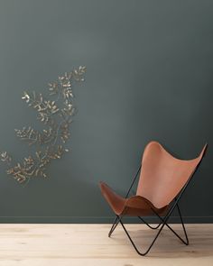 a chair sitting on top of a hard wood floor next to a wall mounted plant