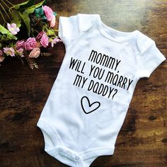 These handmade bodysuits are perfect to make any proposal special by involving your little one!  Made with high-quality heat transfer vinyl.   CARE INSTRUCTIONS  Machine wash Inside out Cold water NO bleach or fabric softer Hang to dry (or low tumble dry) Iron inside out with NO steam White Onesie For Gender Reveal With Funny Text, White Onesie With Letter Print For Gender Reveal, Mother's Day Cotton Bodysuit With Letter Print, Fitted T-shirt For Family Matching Gift, Family Matching Cotton Onesie For Mother's Day, White Letter Print Bodysuit As Gift, Family Matching Custom Print Onesie For Gender Reveal, Family Matching Onesie With Letter Print As Gift, Family Matching Onesie With Letter Print