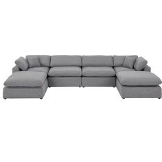 a gray sectional couch with pillows on it's back and the seat facing outward