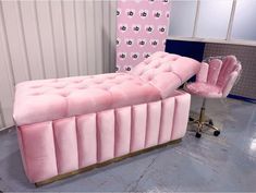 a pink couch sitting on top of a metal chair next to a wall with hearts