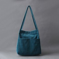 a teal colored handbag on a gray background