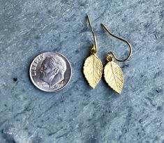 "Gold Leaf Earrings Detailed leaf earrings, in 24K gold-plated sterling silver, with a slight satiny finish. Double-sided detail, with tiny .925 stamp of authenticity on reverse. (Shown in photo #4). Solid and lightweight, they dangle from gold filled ear wires. Leaf measures 17x9 mm (about 5/8\" in length) Total earring length is about 1-1/8\" (28mm), including ear wires METAL COMPONENTS: Leaves: 24K gold plated sterling silver Ear wires: 14k gold filled All earrings come with silicone backs to Small Gold Earrings For Gift, Gold Leaf-shaped Nickel-free Earrings, Gold Earrings For Gift, Minimalist Gold Leaf Earrings, Gold Leaf-shaped Earrings For Gift, Gold Leaf Earrings For Gift, Small Gold Nickel-free Earrings, Everyday Gold Leaf-shaped Jewelry, Everyday Gold Leaf Jewelry