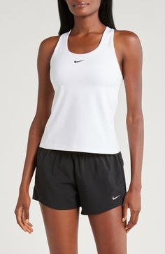 A built-in shelf-bra keeps you supported in this racerback tank top cut with signature Dri-FIT technology for cool, dry comfort as you work up a sweat. 20 1/2" length (size medium) Scoop neck Racerback Built-in shelf-bra Dri-FIT moisture-wicking technology 82% polyester, 18% spandex Machine wash, line dry Imported Nike Tops For Light Sports, White Go-dry Racerback Tank Top, White Racerback Tank Top For Sports, Nike Racerback Activewear For Light Sports, Nike Sporty Racerback Tops, Nike Casual Running Tank Top, Casual Nike Tank Top For Running, White Racerback Top With Mesh Back, White Mesh Back Racerback Top