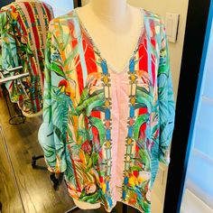 Such A Gorgeous Print Of Flowers And Birds On This Easy To Wear Blouse. The V Neck And Convertible Sleeves Makes It Super Stylish. Designed With A Vibrant Multicolor Tropical Print, It Gives You Effortless Versatility. That Lush, Tropical Details Make This Blouse Truly Something Special. Made Of Ultra-Soft Silk, It Will Quickly Become Your Favorite Piece To Layer This Season. From Parties To Walks Around The City, You Can Pair This With Your Favorite Skirt Or Jeans For A Laid-Back Boho Look. V-neck Top With Tropical Print For Brunch, Summer V-neck Blouse With Tropical Print, Tropical V-neck Blouse For Beach, V-neck Tropical Print Blouse For Beach, Beachwear V-neck Tops With Tropical Print, Chic Vacation Tops With Blouson Sleeves, Chic Tops With Blouson Sleeves For Vacation, Long Sleeve Printed Beachwear Tops, Bohemian V-neck Tops With Tropical Print