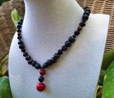 A striking bohemian gemstone and wood bead necklace; crafted with painted black wood beading, black pressed Czech glass beading, matte black agate stone, polished mahogany obsidian stone, and a handmade stone pendant with earthy polished tree agate stone, polished red tourmaline stone, and polished red coral stone. *Handmade by me, one of a kind. *Hypoallergenic stainless steel chain and clasp.  Nickel Free. *Total Length: 18 inches *Length of Chain: 15 inches *Extender Length: 2 inches. If you require a longer extension chain to ensure a proper fit, please let me know!  Just let me know how long you would like your extension chain under personalization instructions. (free of charge) *Diameter of Coral Stone: 12 mm *Pendant Length: 3 cm *Clasp and Chain Material: Lobster claw and jump ring Festival Black Necklace With Gemstone Beads, Black Gemstone Bead Necklace For Festival, Black Gemstone Beads Necklace For Festival, Black Gemstone Beaded Necklace For Festival, Black Gemstone Beaded Necklaces For Festivals, Artisan Black Necklaces With 8mm Beads, Black Wooden Beaded Necklaces For Festival, Artisan Black Necklace With 108 Beads, Artisan Black Beaded Necklaces With Wooden Beads