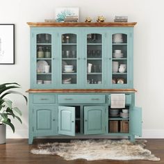 a blue china cabinet with glass doors and shelves