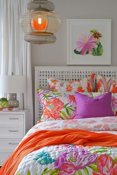 an orange and pink comforter on a white bed