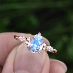 "This is a 1.3 carat natural moonstone engagement ring in solid gold,about 6X8mm pear cut. The accent stones are round 1.5mm and marquise 2x4mm moissanites. It can be made in any ring size. However please contact me to custom make it to a special big or small size. It can be made in white gold,rose gold or yellow gold with 14k or 18k. However for some people who are nickel allergic,I can also make it to 925 sterling silver to make you can wear it. The ring is handmade,very high quality! 30 days Gift Pear Shaped Ring With Rose Cut Diamonds, Pear Shaped Rose Cut Diamond Ring For Gift, Pear-shaped Rose Cut Diamond Ring For Gift, Solitaire Pear-shaped Promise Ring Jewelry, Teardrop Solitaire Jewelry For Anniversary, Pear-shaped Solitaire Promise Ring, Diamond White Gemstone Promise Jewelry, Diamond White Promise Jewelry With Gemstone, Diamond White Gemstone Jewelry For Promise