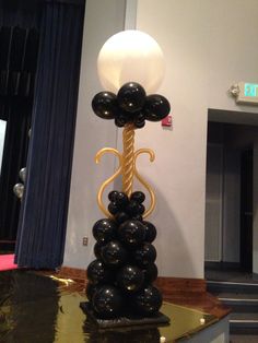 a tall balloon sculpture with black balloons on it