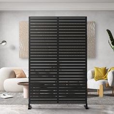 a living room with two white chairs and a black sliding door in the middle of it