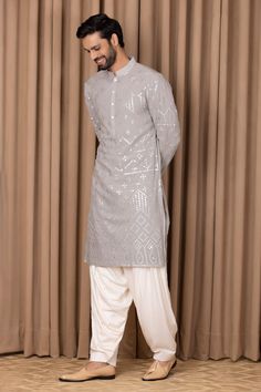 Steel grey straight kurta with mirror embroidery on the front and sleeves. Comes with dhoti pant.
Component: 2
Pattern: Embroidered
Type Of Work: Mirror Work
Neckline: Mandarin Collar
Sleeve Type: Straight Long
Fabric: Pure Georgette, Lining: Cotton
Color: Grey
Other Details: 
Front button placket
Occasion: Sangeet - Aza Fashions Semi-stitched Chanderi Sherwani With Mirror Work, Chanderi Sherwani With Mirror Work, Eid Embroidered Long Sleeve Fabric With Mirror Work, Festive Unstitched Long Sleeve Suit With Mirror Work, Long Sleeve Cotton Silk Salwar Kameez With Mirror Work, Semi-stitched Bandhgala With Chikankari Embroidery In Straight Kurta Style, Semi-stitched Bandhgala With Chikankari Embroidery And Straight Kurta, Eid Long Sleeve Embroidered Fabric With Mirror Work, Traditional Unstitched Suit With Mirror Work And Long Sleeves