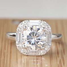 an engagement ring with a large diamond surrounded by small round and baguette cut diamonds