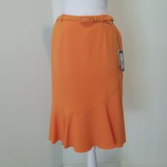 This Ny&Co. Orange (Tangerine) Tulip Midi Skirt Features Tulip Hemline, Side Buttons, Lining, Side Zipper And Hook Closure, Belt Loops, And Matching Belt. Rock This Flirty Skirt With A Pair Of Your Favorite Heels! Approx. Measurements: Length 25", Waist 33", Hip 20 1/2", Hem Width 30 1/2" Fitted High-waist Orange Mini Skirt, Fitted High Waist Orange Mini Skirt, Orange Fitted Mini Skirt, Fitted Orange Mini Skirt, Fitted Orange Pleated Skirt, Fitted Orange Mini Skirt For Spring, Elegant Fitted Orange Bottoms, Orange Lined Skirt For Workwear, Chic Fitted Orange Mini Skirt