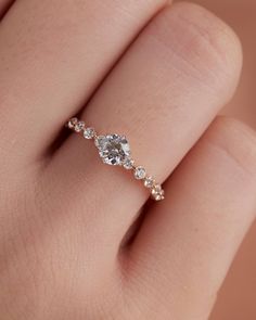 a woman's hand with a diamond ring on top of her finger and an engagement band