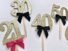 gold glitter cake toppers with black bows and numbers