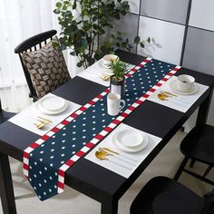 an american flag table runner on top of a dining room table with plates and silverware