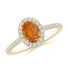 an orange sapphire and diamond halo ring in yellow gold with white diamonds on the band