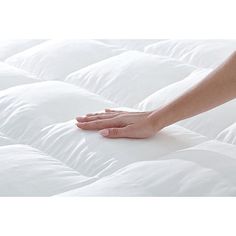 a person's hand on top of a white mattress