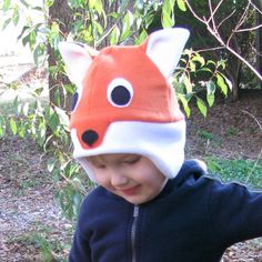 a little boy wearing a hat with a fox design on it's face and ears